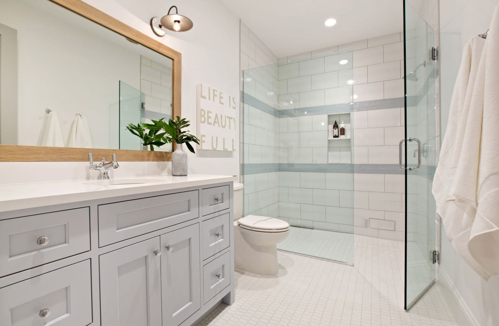 White tile bathroom with glass door walk in shower