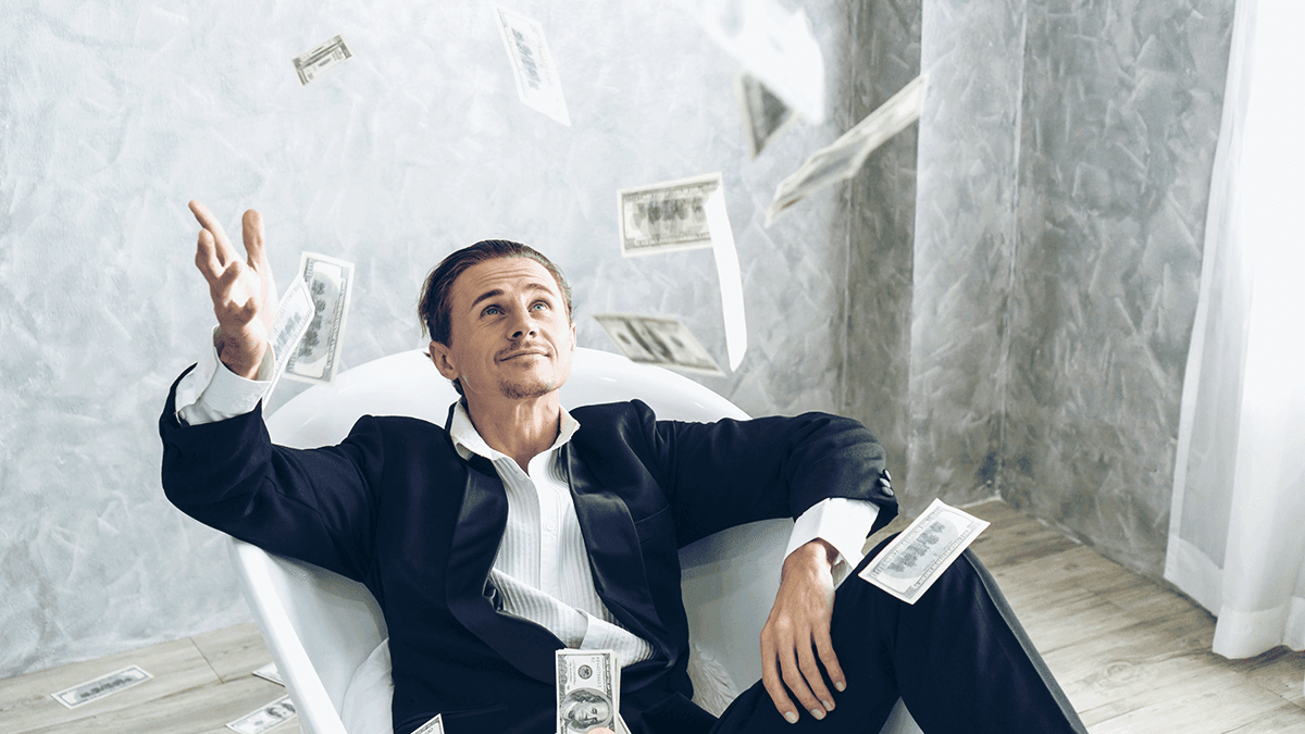 Businessman in suit sitting in white bathtub, tossing dollar bills in the air with a satisfied expression