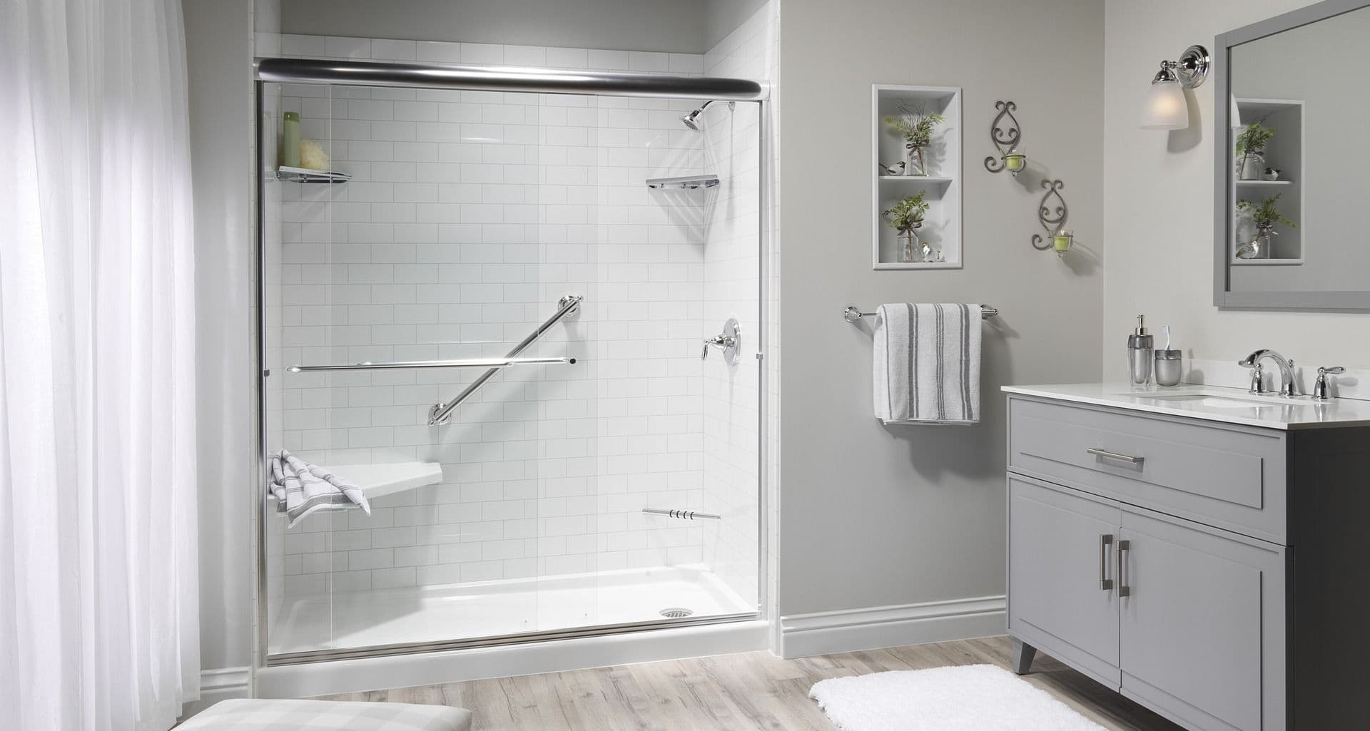 A sleek white modern shower with glass doors and ADA compliant fixtures